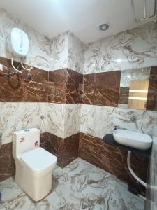 um banheiro com vaso sanitário e pia em Hotel Sanwariya em Gandhinagar