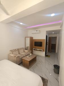 um quarto com uma cama, um sofá e uma TV em Hotel Sanwariya em Gandhinagar