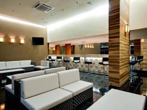 a waiting room with white couches and a bar at Apartamento Suites Le Jardin Caldas Novas Goiás in Caldas Novas