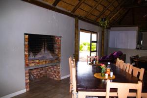 a dining room with a fireplace and a table and chairs at Maskam Guest Farm in Vanrhynsdorp