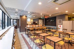 a restaurant with wooden tables and yellow chairs at Comfort Hotel Yokohama Kannai in Yokohama