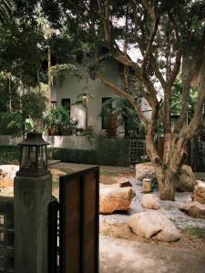 a fence in front of a house with a tree at The Memory Khaoyai in Pong Talong
