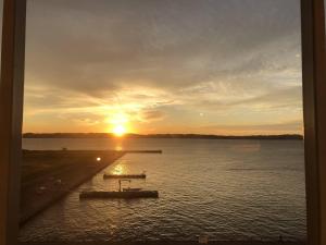 ein Sonnenuntergang über einem großen Gewässer in der Unterkunft Comfort Hotel Central International Airport in Tokoname