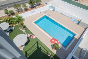 
a patio area with a pool and a tennis court at Napasol Boutique Hotel in Ayia Napa
