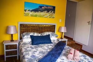 a bedroom with a bed with blue pillows and two lamps at Maskam Guest Farm in Vanrhynsdorp