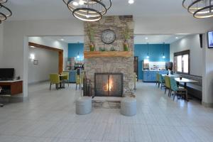 a lobby with a fireplace and tables and chairs at Brookstone Lodge near Biltmore Village, an Ascend Collection Hotel in Asheville
