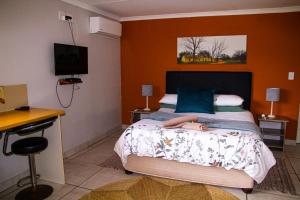 a woman laying on a bed in a bedroom at Maskam Guest Farm in Vanrhynsdorp