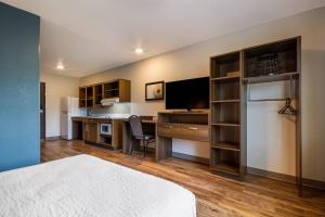 a room with a bed and a desk with a computer at WoodSpring Suites Panama City Beach in Panama City Beach