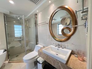 um banheiro com uma pia, um vaso sanitário e um espelho em Shanghai Hongmin Inn em Xangai mais 47 fotografias