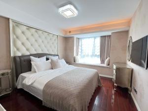 um quarto com uma cama grande e uma janela em Shanghai Hongmin Inn em Xangai