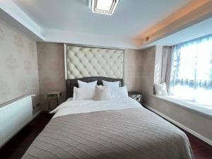une chambre avec un grand lit et une fenêtre dans l'établissement Shanghai Hongmin Inn, à Shanghai 47 autres photos