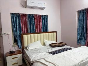 a bedroom with two beds and a tv on the wall at Hotel O Aditi Guest House in Salt Lake City