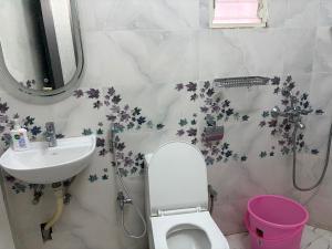 a bathroom with a sink and a toilet and a mirror at Hotel O Aditi Guest House in Salt Lake City