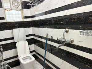 a bathroom with a white toilet and a sink at Hotel O Aditi Guest House in Salt Lake City