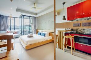 a bedroom with a bed and a kitchen with a table at 405 Relife , 5 Minutes Walk To Nai Harn Beach in Rawai Beach