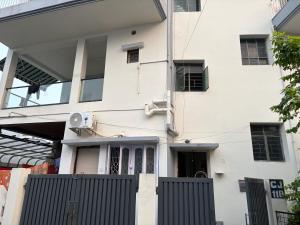 a white house with a gate in front of it at Hotel O Aditi Guest House in Salt Lake City