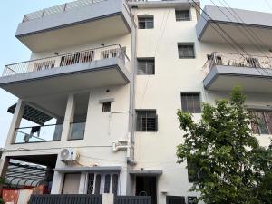 a white building with a balcony on it at Hotel O Aditi Guest House in Salt Lake City