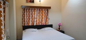 a bedroom with a white bed with a window at Hotel O Sharan Guest House in Calcutta Bara Bazar +12 photos