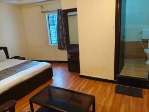 a bedroom with a bed and a glass table at Hotel O Laxmi Narsimha Temple Banjara Hills in Hyderabad
