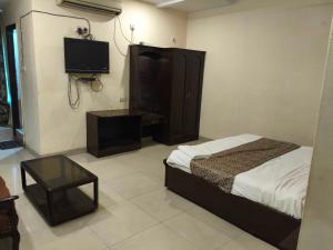 a bedroom with a bed and a tv on the wall at Hotel O Laxmi Narsimha Temple Banjara Hills in Hyderabad