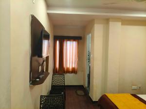 a hotel room with a bed and a television at Hotel O Laxmi Narsimha Temple Banjara Hills in Hyderabad