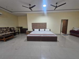 a bedroom with a bed and two ceiling fans at - Hotel O Machilipatnam Railway Station Formerly Hasini Celebrations in Machilīpatnam