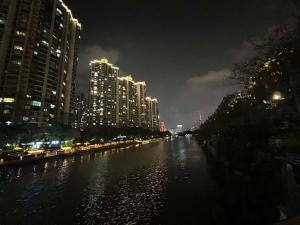 um rio numa cidade à noite com edifícios altos em Shanghai Hongmin Inn em Xangai