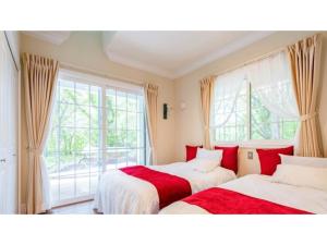 Dos camas en una habitación con ventana. en FARM SIDE - Vacation STAY 24148v, en Tsumagoi