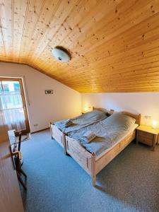 a bedroom with a bed with a wooden ceiling at FeWo Honstein in Pfronten