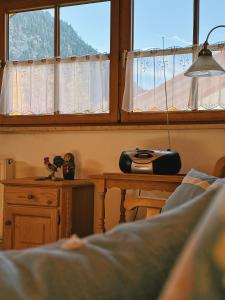 a bedroom with a bed and a table and a window at FeWo Honstein in Pfronten