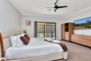 ein weißes Schlafzimmer mit einem großen Bett und einem TV in der Unterkunft Among The Vines in North Rothbury + 31 Fotos