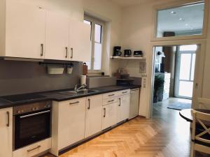 a kitchen with white cabinets and a wooden floor at Ferienwohnung Kotterer - Innenstadt Speyer in Speyer