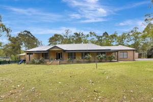 ein Haus mit einem großen Garten davor in der Unterkunft Among The Vines in North Rothbury