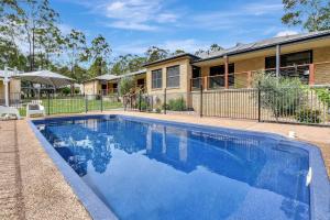 ein Swimmingpool vor einem Haus in der Unterkunft Among The Vines in North Rothbury