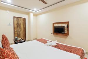 a hotel room with a bed and a tv at Hotel Galaxy Park in Shamshabad