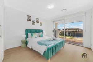 Un dormitorio blanco con una cama y una ventana grande. en Five Bedrooms Near Schofields Station Direct Access to Sydney University & Parramatta, en Schofields 22 fotos más