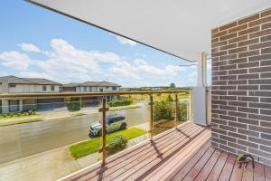 Vista desde el balcón de una casa con un coche en la terraza. en Five Bedrooms Near Schofields Station Direct Access to Sydney University & Parramatta, en Schofields