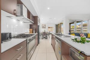 cocina con encimeras blancas y fogones en Five Bedrooms Near Schofields Station Direct Access to Sydney University & Parramatta, en Schofields