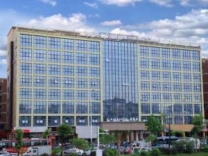 a large yellow building with lots of windows at Lavande Hotel Shenzhen Pingshan High-Speed Railway Station Longdong Metro Station in Longgang