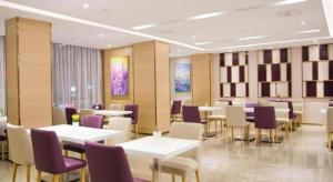 a restaurant with tables and chairs and purple chairs at Lavande Hotel Shenzhen Pingshan High-Speed Railway Station Longdong Metro Station in Longgang