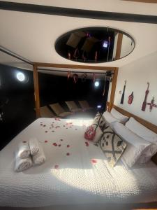 a bedroom with a bed with red rose petals on it at tour des étoiles love room in Trévoux