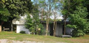 a building with a bench next to some trees at The Camping Field in Ban Kluai