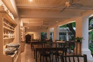 a dining room with tables and chairs and a ceiling at Makka Hotel in Chiang Mai