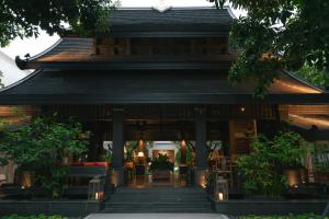 a building with a restaurant with lights in front of it at Makka Hotel in Chiang Mai