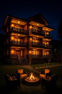 a building with a fire pit in front of it at night at The Manali Suits & Villa - Luxury Stay Away From City Hustle in Manāli