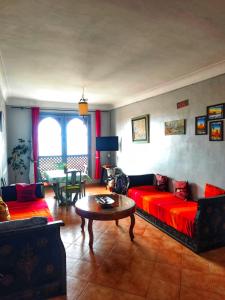 a living room with a red couch and a table at Ocean Hideaway - Sea View in Essaouira +21 photos