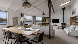 a living room with a table and chairs and a couch at Perfect on Perkins - Lake views in Frankton Wharf