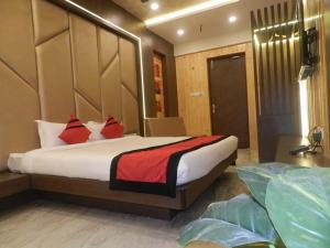 a bedroom with a large bed with red pillows at Hotel The Novelty in Kānpur +6 photos