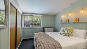 a bedroom with a bed and a window at Perfect on Perkins - Lake views in Frankton Wharf