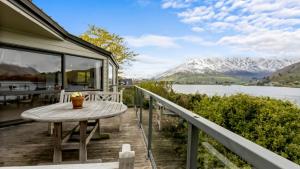 a balcony with a table and a view of a lake at Perfect on Perkins - Lake views in Frankton Wharf
